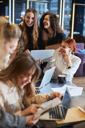 Cheerful young women working together on project in officeの写真素材