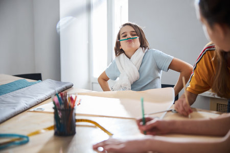 Adorable girl having fun in sewing workshopの写真素材
