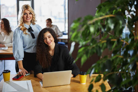 Cheerful female colleagues working together in office