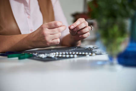 Craftswoman making a new necklace in her studioの写真素材