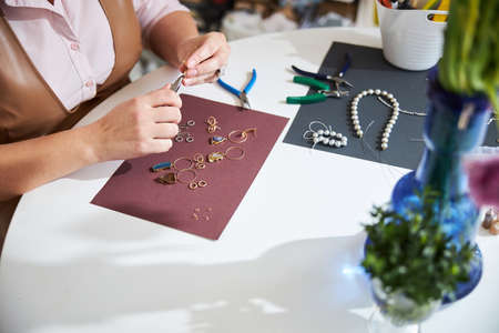 Female jeweler making gold earrings in her workshopの写真素材