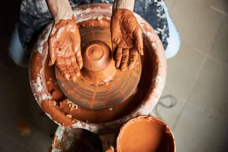 Female potter making clay pot in pottery workshopの写真素材