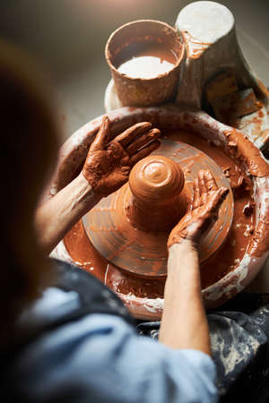 Senior woman hands making earthenware in pottery workshop