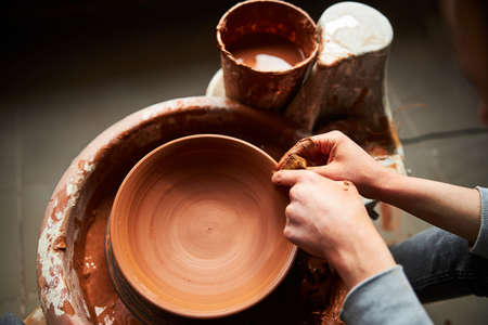 Potter hands making clay bowl on pottery wheelの写真素材