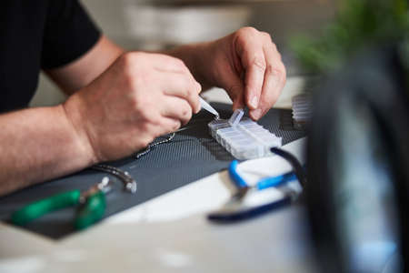 Handcrafter choosing a metal detail for his new jewelry item
