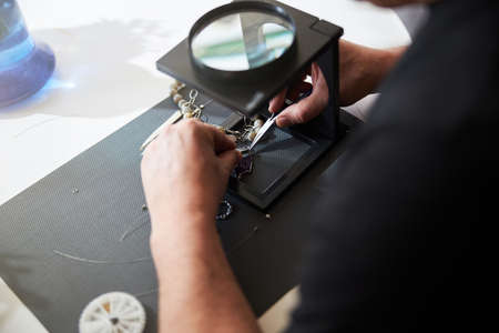Jeweler working with a magnifier and jewelry tools