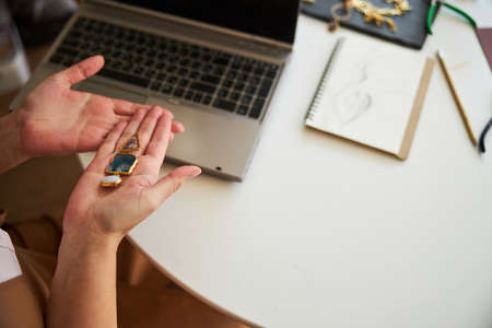 Woman with a handcrafted jewelry item sitting at the table