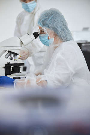 Virologists viewing a viral specimen on the glass slide
