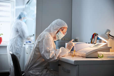 Two virologists performing chemical tests in a research lab
