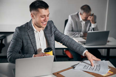 Cheerful young man working with colleague in office