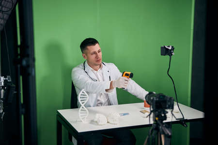 Handsome male doctor recording video for medical blogの写真素材