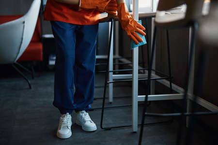 Professional female cleaner doing the cleaning in the cafeteriaの写真素材