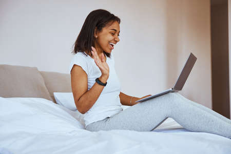 Charming young woman using laptop for online communication