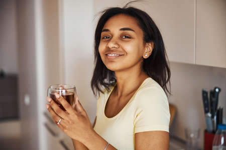 Beautiful Afro American woman drinking tea at homeの写真素材