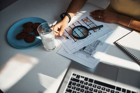 Female architect drawing building plan at home