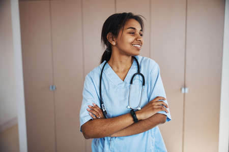 Joyful female doctor with stethoscope standing in clinicの写真素材