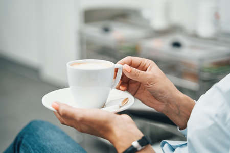 Female customer drinking a hot beverage before a cosmetic procedureの写真素材