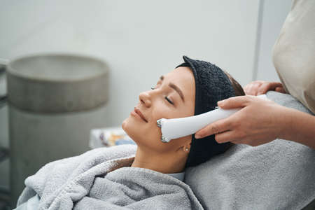 Calm beauty salon customer undergoing a face-lift procedureの写真素材