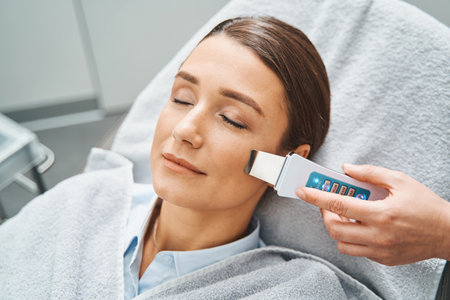 Female patient having her blackheads removed with an ultrasonic scrubber
