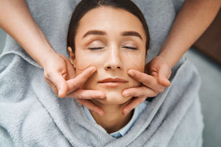 Young spa customer receiving a professional facialの写真素材