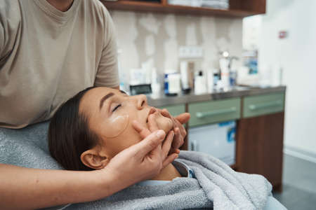 Beautiful lady dozing during a face-lifting massage