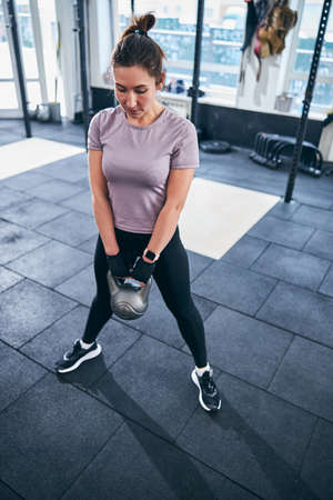 Female bodybuilder working out with a kettlebellの写真素材