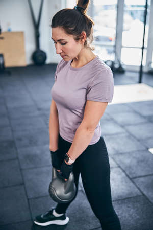 Serious dark-haired sportswoman doing a strength exerciseの写真素材