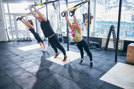 Three Caucasian sportspeople doing a resistance exercise