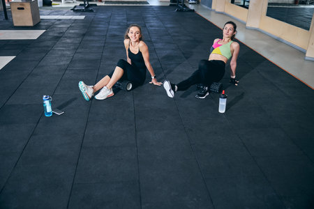 Two women doing an exercise using foam rollersの写真素材