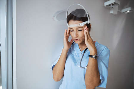 Nice female doctor suffering from headache at workの写真素材