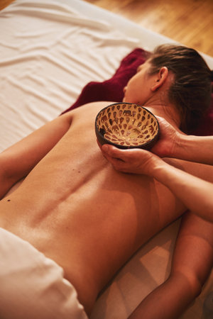 Dish with body oil staying on woman backの写真素材