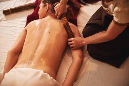 Spa worker tending shoulder muscles with massage rollerの写真素材