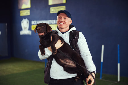 Happy male trainer and an obedient adult dog