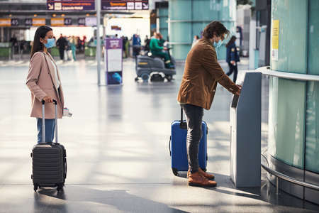 Passengers using automatic hand sanitizer at airport