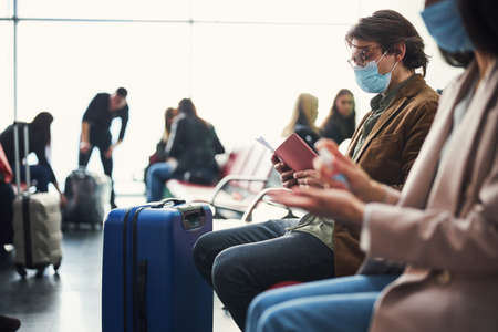 Passengers waiting for the flight at airport during pandemicの写真素材