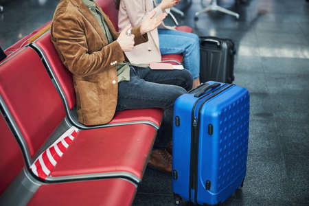 Male passenger using hand sanitizer at airportの写真素材