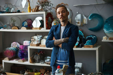 Handsome young in stylish outfit man standing in workshopの写真素材