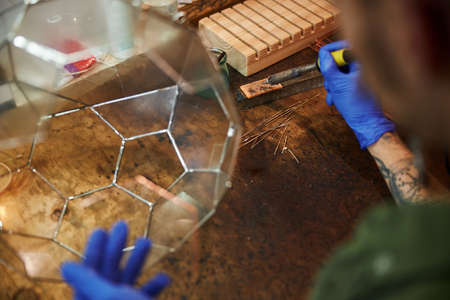 Young man making glass florarium in workshopの写真素材