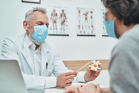 Doctor explaining the spine anatomy basics during the patient consultation