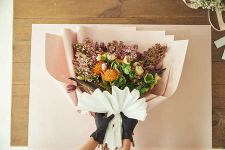 Female decorating an exotic bouquet with a folded paper fanの写真素材