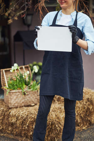 Smiling pleased Caucasian female floriculturist standing outsideの写真素材