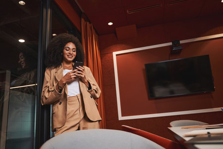 Mirthful woman standing in the meeting room near the doorの写真素材
