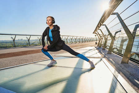 Smiling female training legs in fresh air