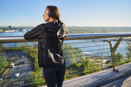 Calm young woman enjoying scenery outdoors after workoutの写真素材