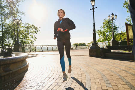 Cheerful woman enjoying cardio workout in park