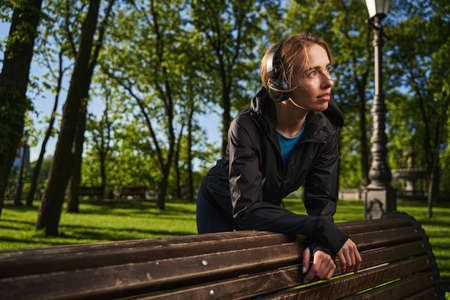 Happy young woman enjoying music in parkの写真素材