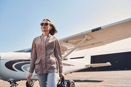 Stylish young woman standing outdoors at airport