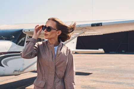 Elegant young woman standing outdoors at airportの写真素材