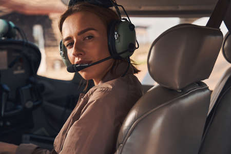 Beautiful young woman sitting inside plane cockpitの写真素材