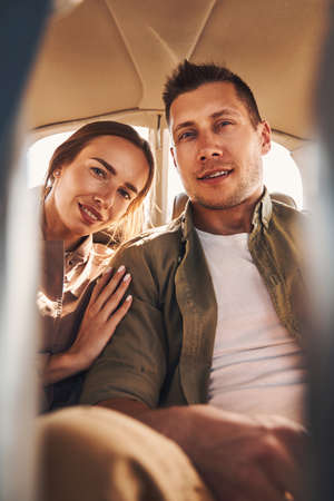 Beautiful young couple in love sitting in vehicle